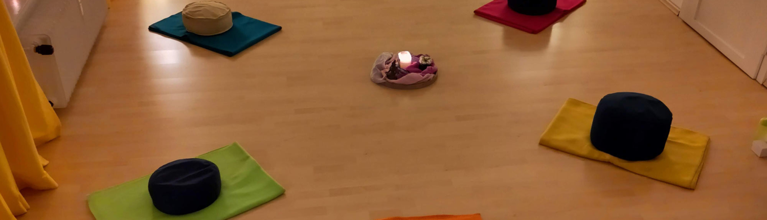 Raum mit Matten und Sitzkissen und Kerze in der Mitte Raum mit Matten und Sitzkissen und Kerze in der Mitte